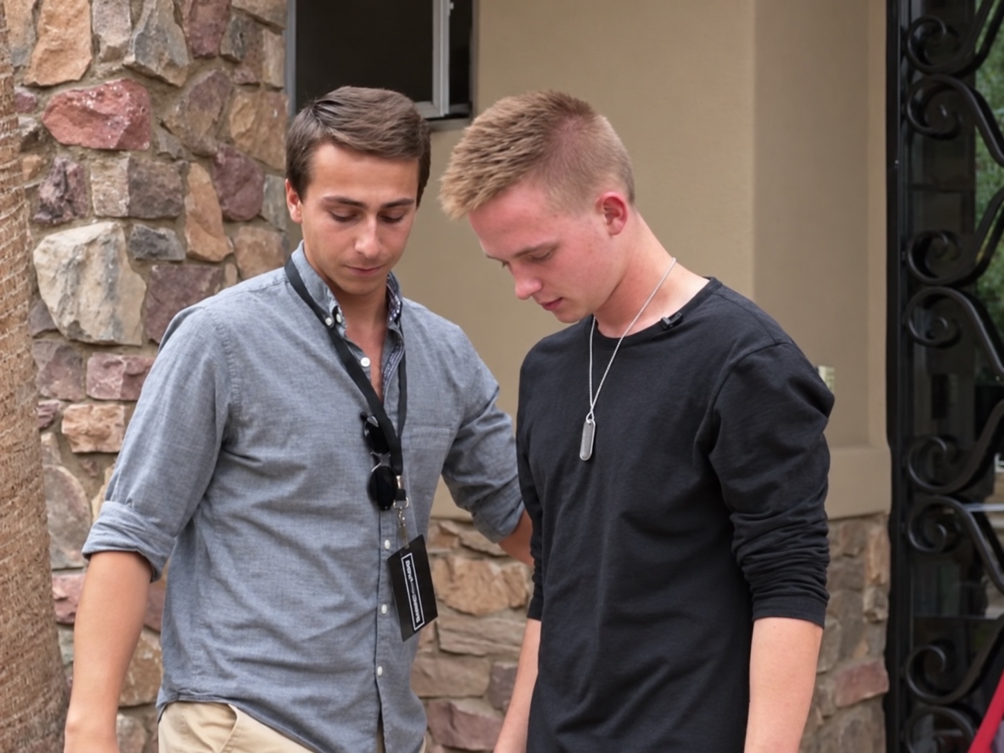 Tyler beside a participant with their head lowered and eyes closed during a hypnosis demonstration.